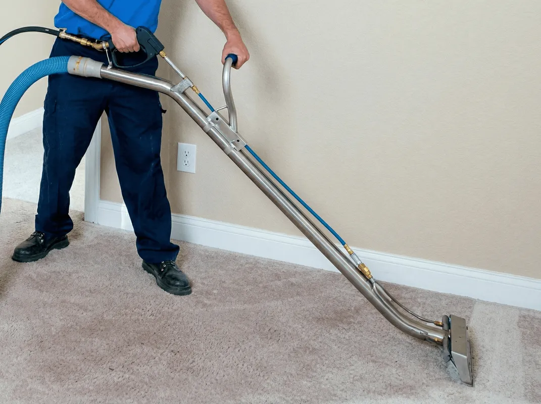 Professional operating a liquid removal machine on a carpeted floor in Ann Arbor, MI